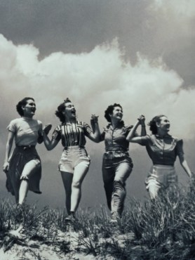 four-women-walking-in-a-line-holding-hands